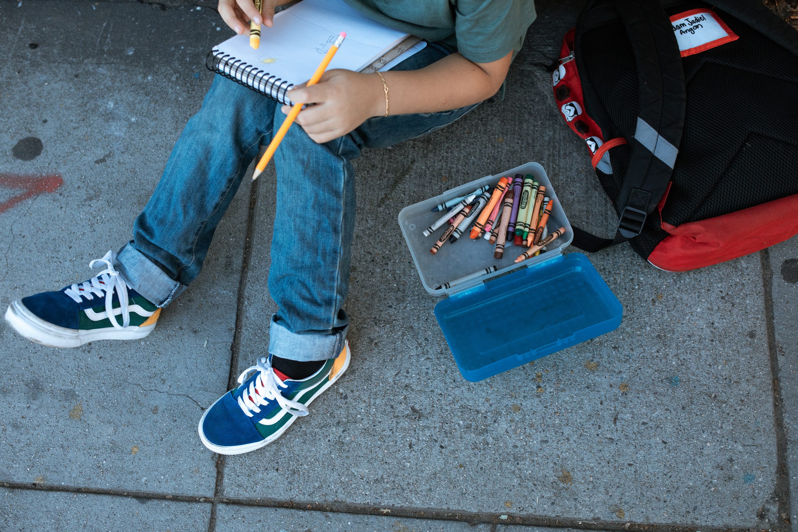 child writing and crayons